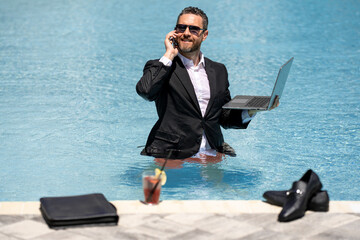 Crazy Summer business. Businessman in suit wit laptop in swimming pool. Crazy summer freelancer...