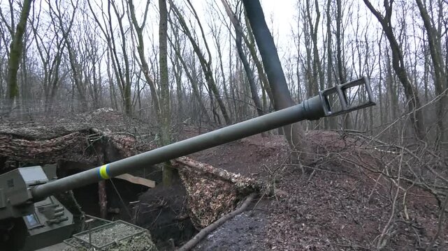 Disguised in a shelter, in a pit, the combat vehicle raises the muzzle for a shot. Fighting from a protected place. Defense of the Ukrainian army. Russo-Ukrainian war.