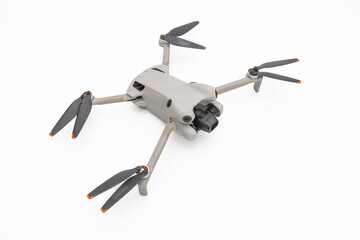 High angle view of a modern grey quadcopter drone with a camera and propellers, isolated on a white...