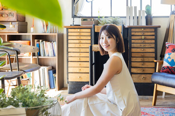 ラグに座るワンピースの女性