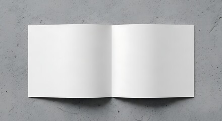 Open blank book with white pages on a textured gray background, top view.