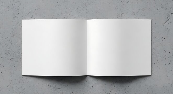 Open blank book with white pages on a textured gray background, top view.