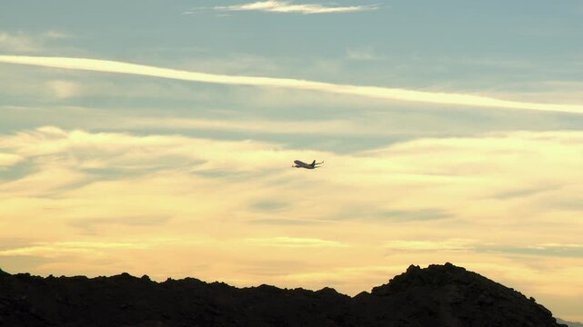 Golden morning aircraft lifts off into cloudy sky with copy space