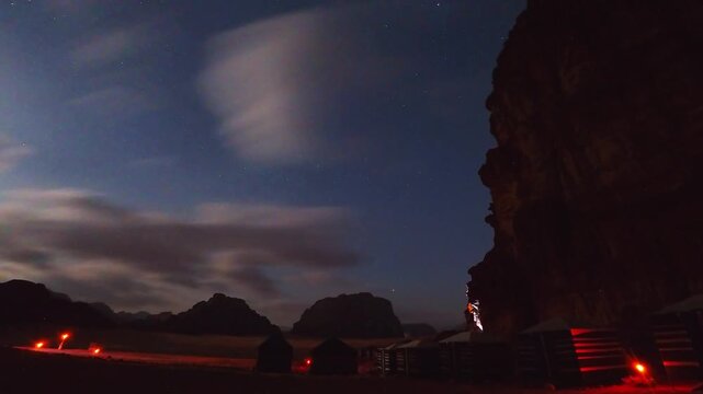 Time lapse Bedouin desert camp glowing with red lights under star filled night sky isolated remote wilderness travel scene