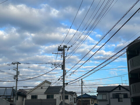 住宅地の電柱とそれに張り巡らされた配線