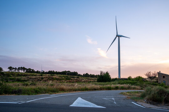 Dusk landscape with wind turbine near road under sky in the Terra Alta region of Catalonia Spain with renewable energy travel mood
