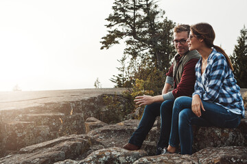 Fototapeta premium Thinking, couple and smile for hiking on mountain with vision, trekking and bonding together. Space, people and relax on cliff for reflection outdoor, fresh air and daydreaming with nature view