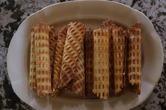 Homemade Golden Crispy Waffle Rolls on a White Plate, Overhead View