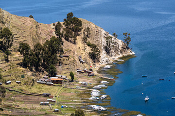 Isla del Sol, Bolivia: Aerial view of the Isla del sol, the sun island with terrace agricultural field and speed boats along its coastline on the lake titicaca in the Andes in the Bolivia