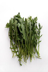 Fresh arugula leaves. White background, detail top view.