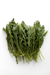Fresh arugula leaves. White background, detail top view.