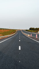 Fototapeta premium Highway stretching far with no visible cars on a clear day in an open landscape