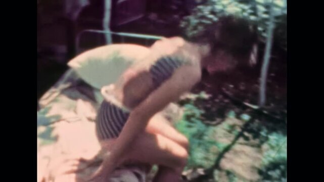 Young adult woman in swimsuit sunbathing in rural backyard. Sunny summer vacation at cottage. Relaxed female enjoying vacation relaxation at countryside. Old film. Archival retro. Vintage archive