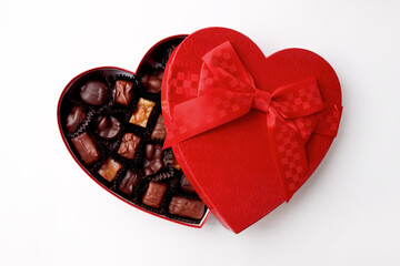 Chocolates in a red heart-shaped box. Isolated on a white background.