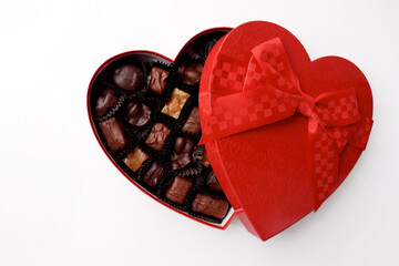 Chocolates in a red heart-shaped box. Isolated on a white background.
