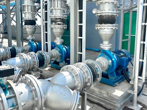Industrial water pump station and pipeline system installed outdoors. Featuring high-pressure centrifugal pumps, silver metallic pipes, and professional cable management, this infrastructure setup is 