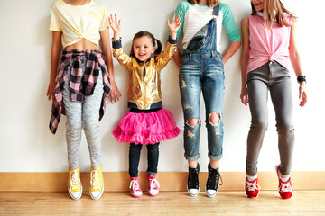 Naklejka premium Portrait, girl and children in dance studio with fun, funky fashion and stretching for practice by wall. Happy, dancer and kids in creative school with trendy style, rehearsal and warm up for rhythm.