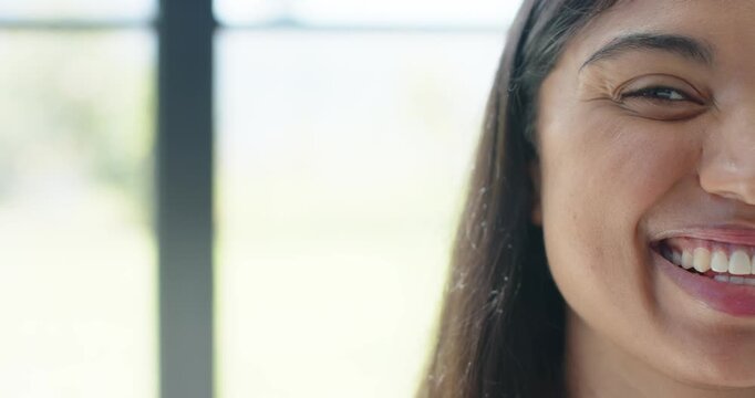 Female reacting to unseen cue smiling widening into big grin by multi-pane window, copy space