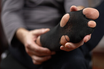 Closeup shot of male feets in a hoaly blacks socks. Concept of poverty and financial crisis