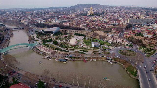 aerial view of Tbilisi Rike Park Peace Bridge and old town along Kura river Georgia riverside promenade and the white balloon structure in the park modern landmarks and river landscape