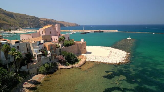 Aerial panorama of Terrasini with sunlit buildings and gentle waves Drone flyover showcasing Terrasini&rsquo;s beach, harbor infrastructure, and coastal architecture.
Cinematic dron