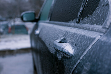 Close-up of a car door coated in thick ice during winter, with blurred background. Perfect for seasonal, weather, and automotive concepts.