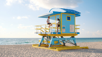 Enjoying sun-soaked moments at Miami Beach lifeguard station with vibrant blue skies