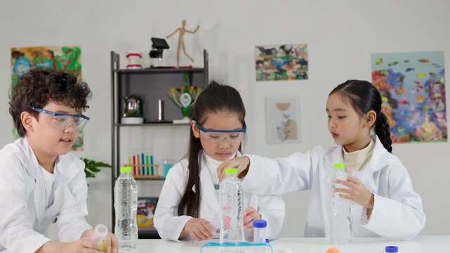 Asian Children in Lab Coats Conducting Bernoulli Principle Science Experiment