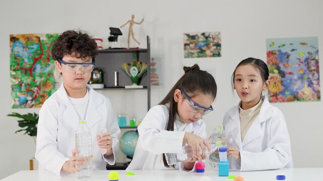 Asian Students in Lab Coats Conduct Bernoulli Principle Science Experiment