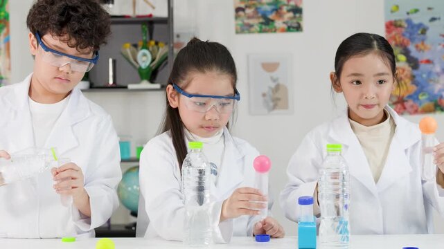 Asian Students Conducting Bernoulli Principle Science Experiment with Ping Pong Balls
