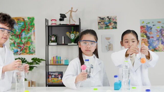 Asian Students Performing Bernoulli's Principle Science Experiment in Classroom Laboratory