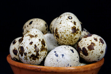 Obraz premium Quail eggs on black background, close-up shot