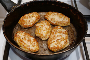 Meat cutlets are fried in a pan. Cooking, frying meat. Five cutlets are cooking