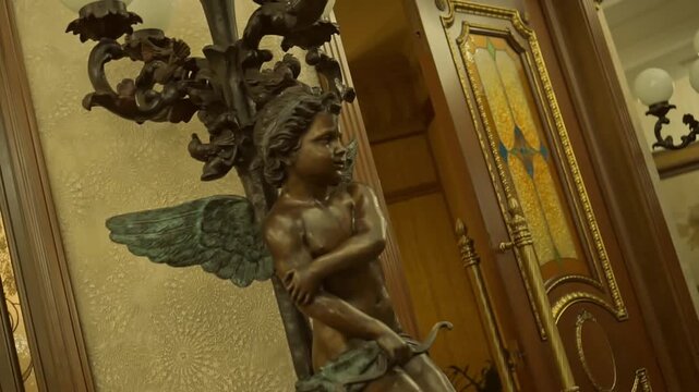 Statue of a little angel in a European hotel. Bronze statue of a child angel with wings.