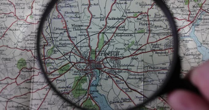 Slow motion footage of an old map from 1904 showing the town of Ipswich in Suffolk, a county in eastern England in the UK and a magnifier magnifying glass looking closer at the historical map