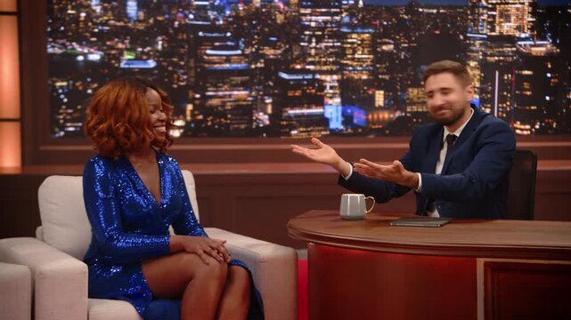 Male Guest Host Talks With a Black Female Performer on a Late Night Talk Show, Jokes and Playful Gossip About Fame, Auditions, Career, Interview. TV Screen Replacement Content. Mockup Playback 
