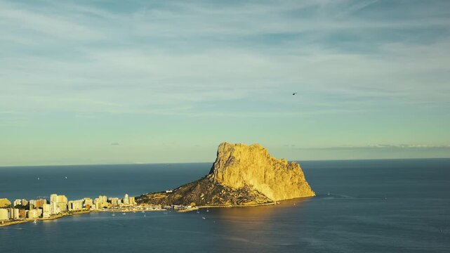 Scenic coastal view of calpe with iconic rock formation at sunrise