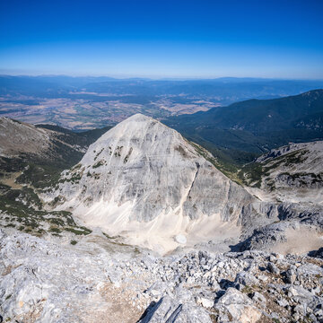 Mt. Tsarna Mogila in Pirin highlands and Bansko town behind it in summer sunny day. View from Mt. Kutelo.