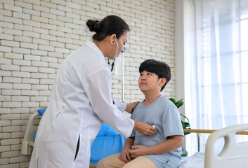 Fototapeta premium Pediatrician examining child patient. Young woman doctor puts stethoscope to little chest and checks.health care and medical concept