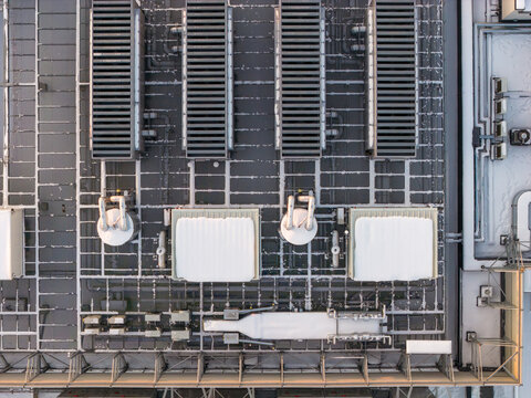 Aerial view of a meticulously structured industrial rooftop reveals a symphony of geometric shapes and contrasting textures, Duchnice, Wojew&Atilde;&sup3;dztwo mazowieckie, Poland.