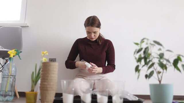 A woman is transplanting flowers into the ground at home