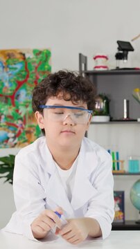 Young Student in Lab Coat Performing Bernoulli's Principle Science Experiment