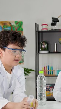 Young Student Performing Bernoulli Principle Science Experiment with Ping Pong Ball