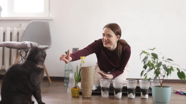 A woman is transplanting flowers into the ground at home