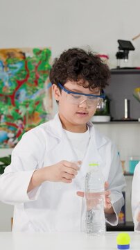 Asian Boy in Lab Coat Performing Bernoulli Principle Science Experiment