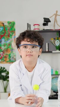 Young Student Demonstrating Bernoulli's Principle with Ping Pong Ball and Tube