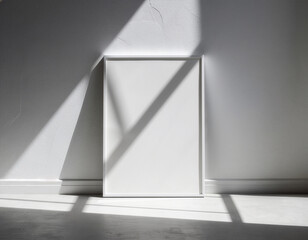 Blank white picture frame mockup leaning against a wall with window shadows