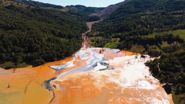 Drone flies through mining waste runoff below polluted lake in Geamăna.