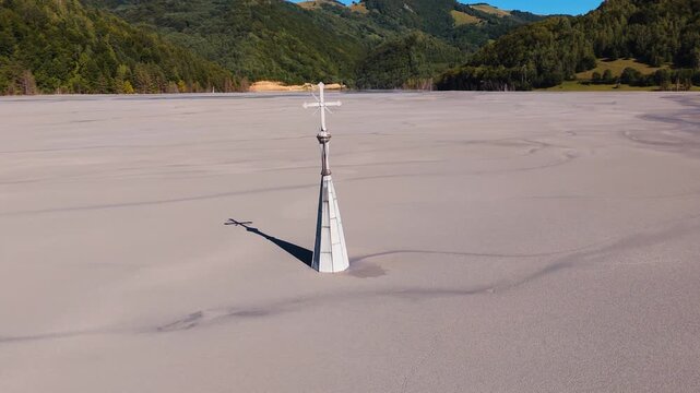 Drone orbits church tower emerging from mining waste in Geamăna.