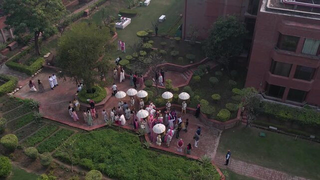Aerial shot of a traditional Indian wedding baraat procession with dancing guests and festive lights